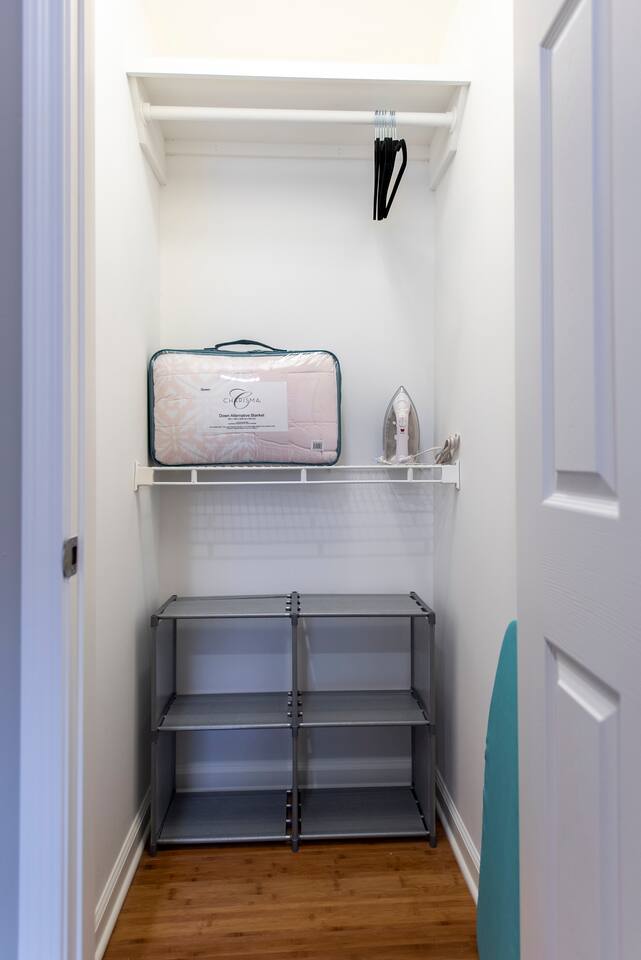 Full closet in Master bedroom with iron and ironing board