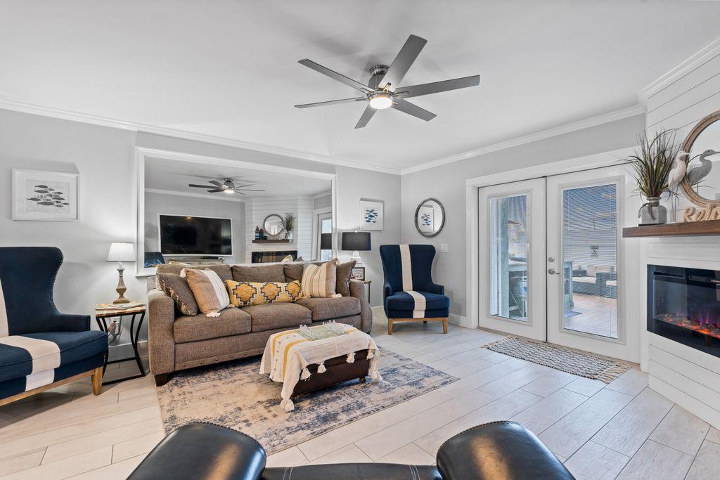 Spacious living area with fireplace, ceiling fan and smart TV