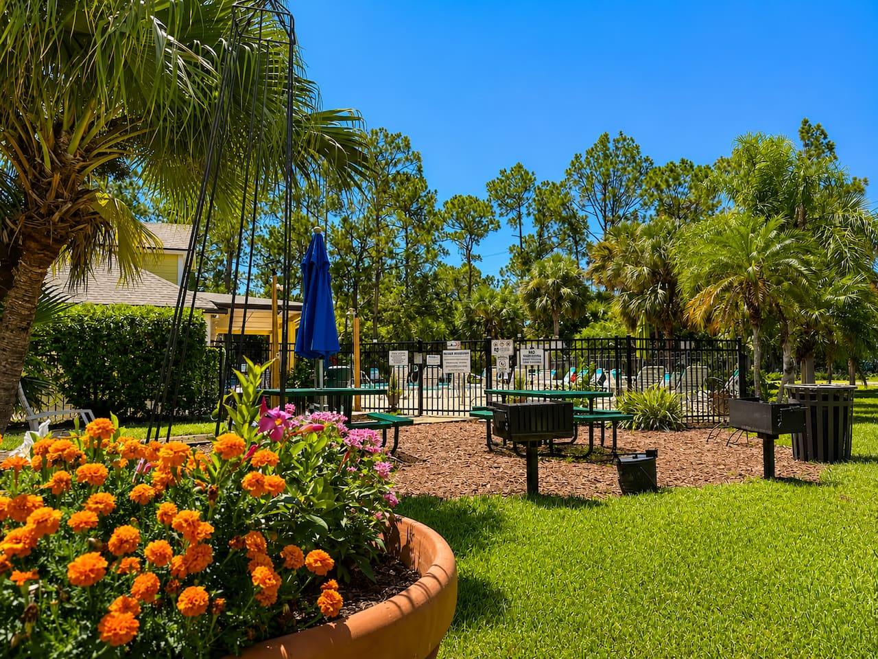 Landscaped community recreation area with shaded seating and space to relax.