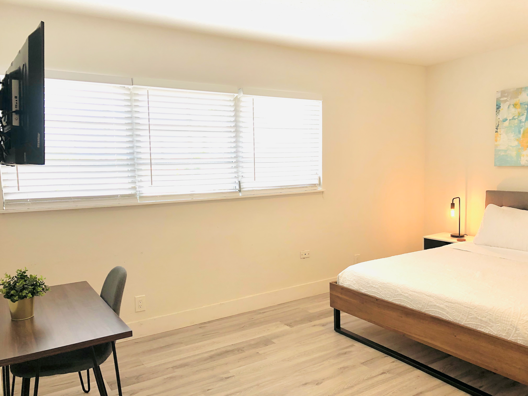 Wide view of primary bedroom and workstation dining set.