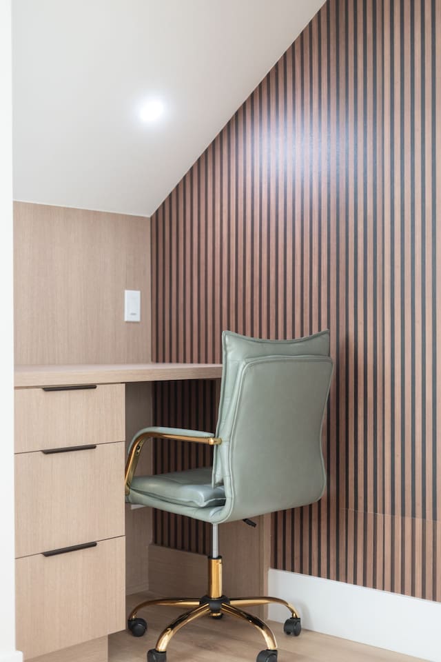 Sleek desk with modern striped accent wall and cozy task lighting.