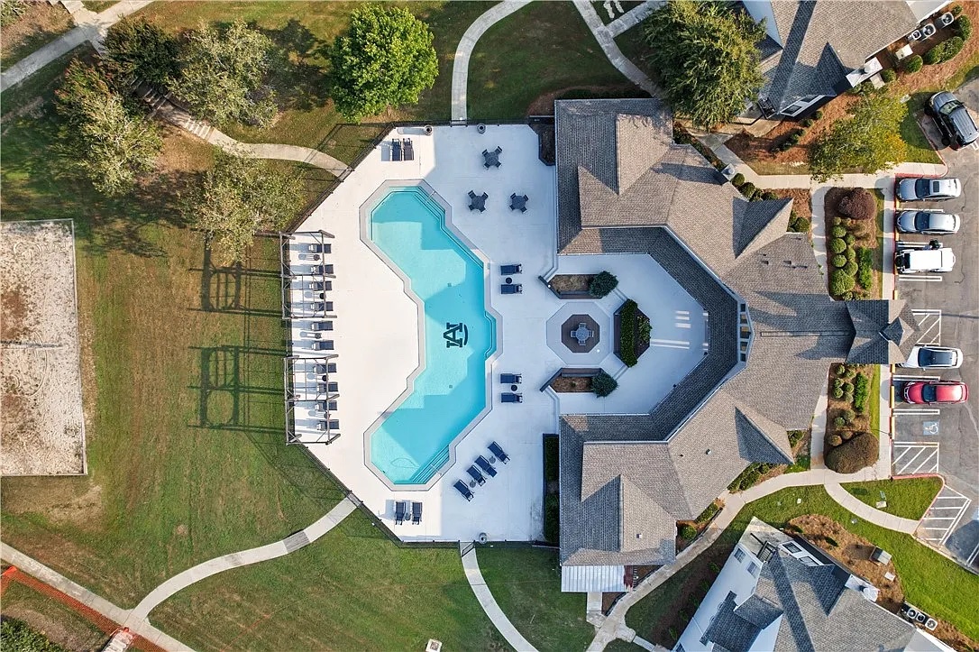 See the whole setup from above — the pool, clubhouse, and courts all sit a short walk from your building.