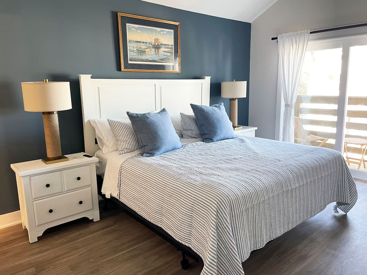 Relax in the spacious primary suite featuring a comfortable king bed, elegant décor, and direct access to the private balcony.