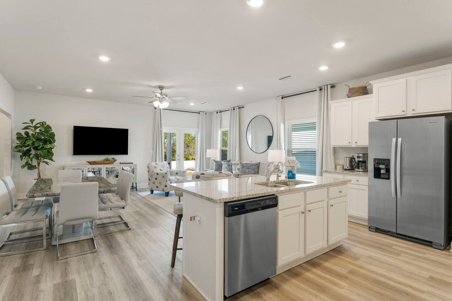Stylish full kitchen with counter seating, stove, microwave, and open layout connecting dining and living area.