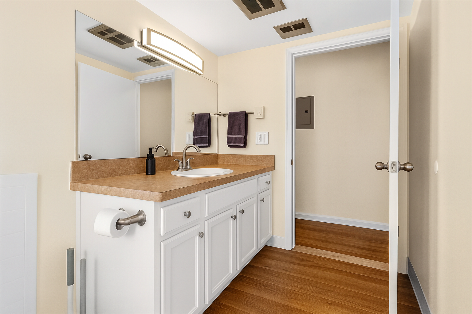 Clean and modern bathroom with full-size tub, granite vanity, and bright lighting.