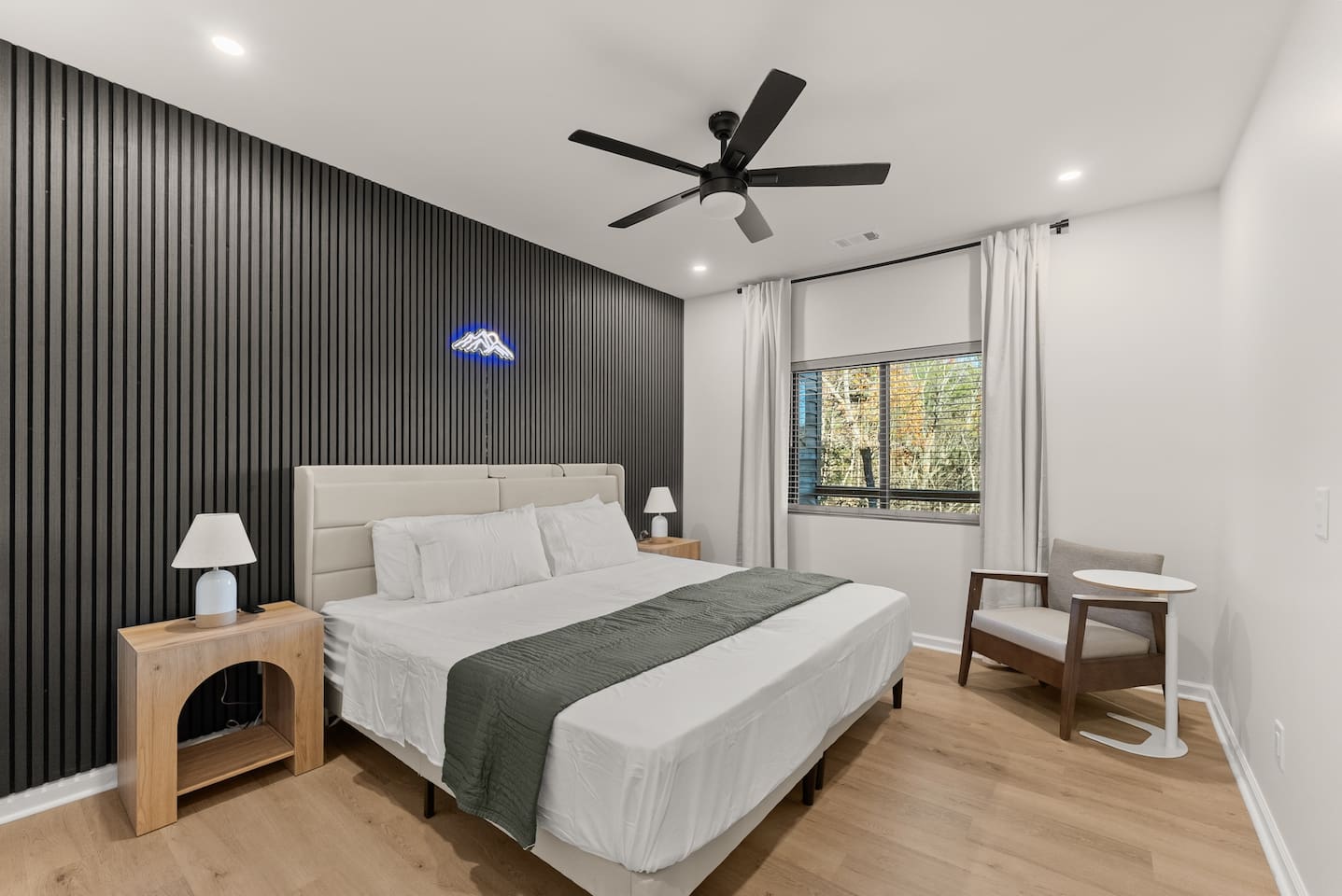 Two flexible twin beds that can convert into a king or stay separate, featuring modern nightstands, wall panels, and a spacious closet—stylish and adaptable for any stay.