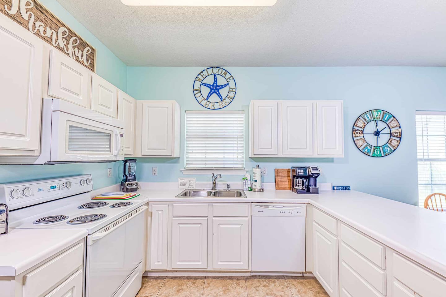 Kitchen: Bright and cheerful space with modern appliances and beachy decor for culinary delights!