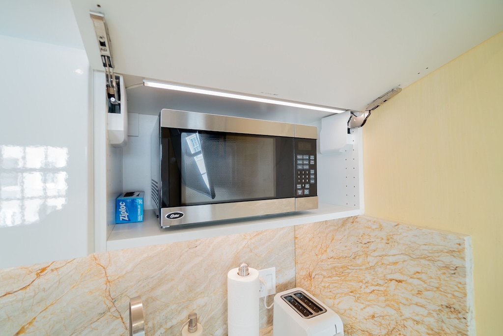 Microwave behind cabinet. Lights up when you open.