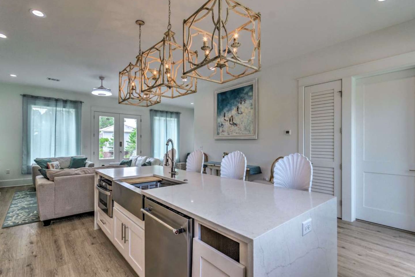 Chef’s kitchen with a microwave drawer, dishwasher, and garburator.  The island features built-in charging ports and stunning Grotto-style chairs with hand-carved seashell backs.  Modern utility meets bespoke coastal design!