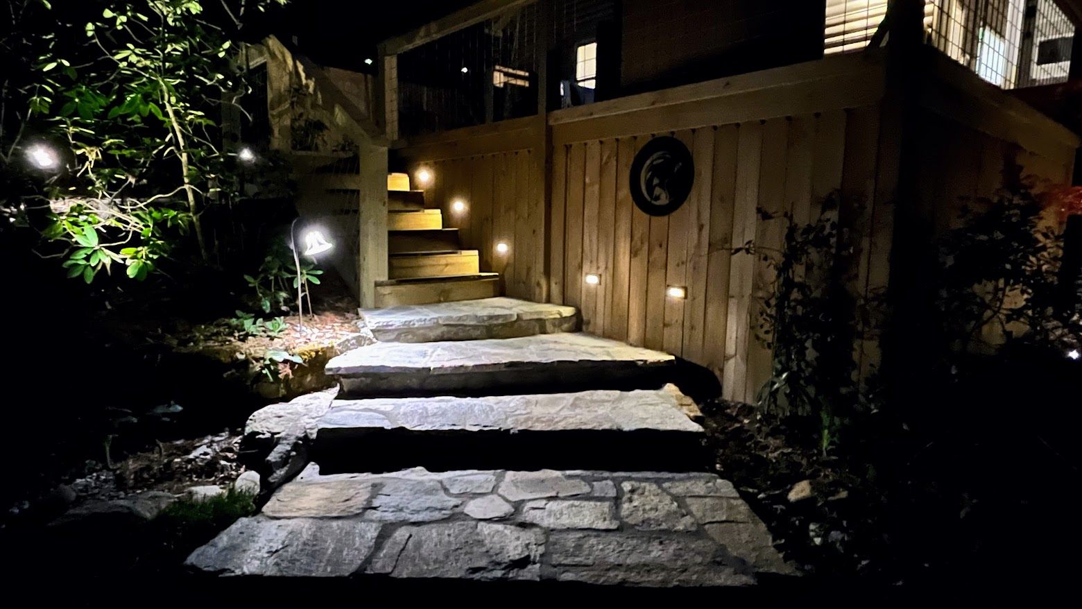 Landscape lighting for security line the stone and wooden steps.