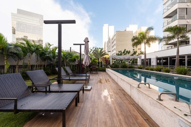 Piscina com deck de madeira e espreguiçadeiras — lazer e relaxamento garantidos em Pinheiros.