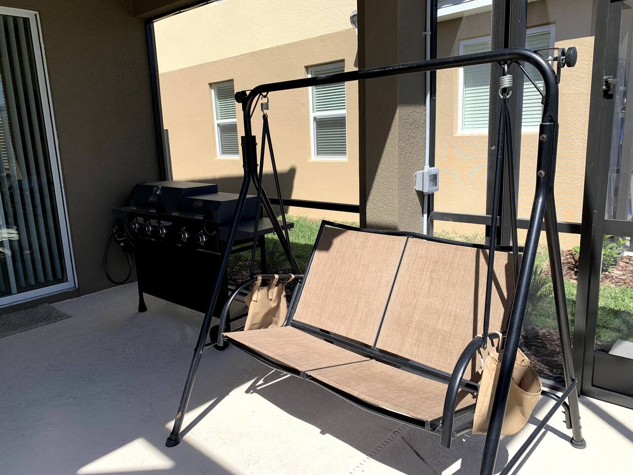 Outdoor swing in enclosed pool area. 