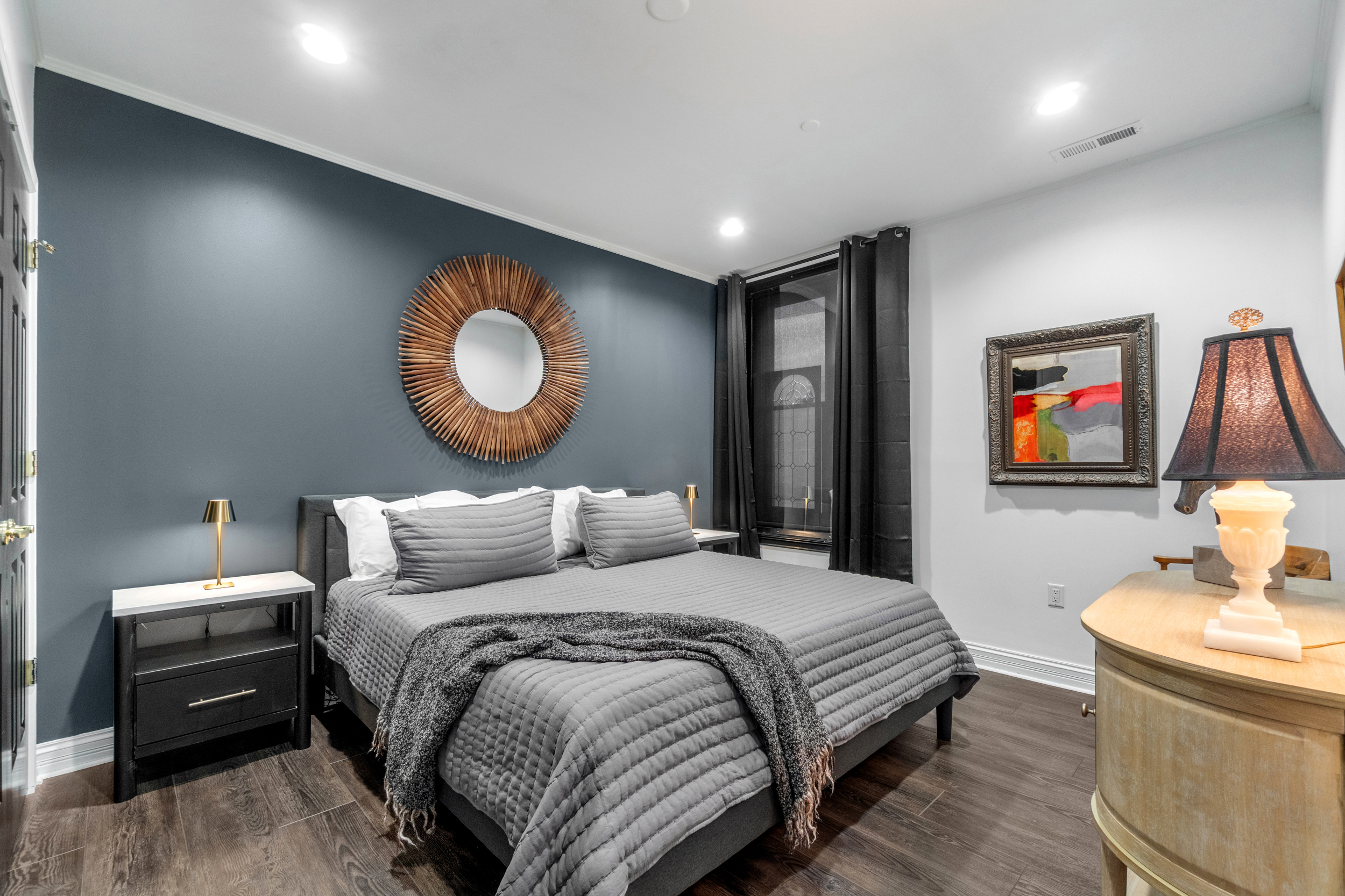 Primary bedroom with king bed and black out curtains