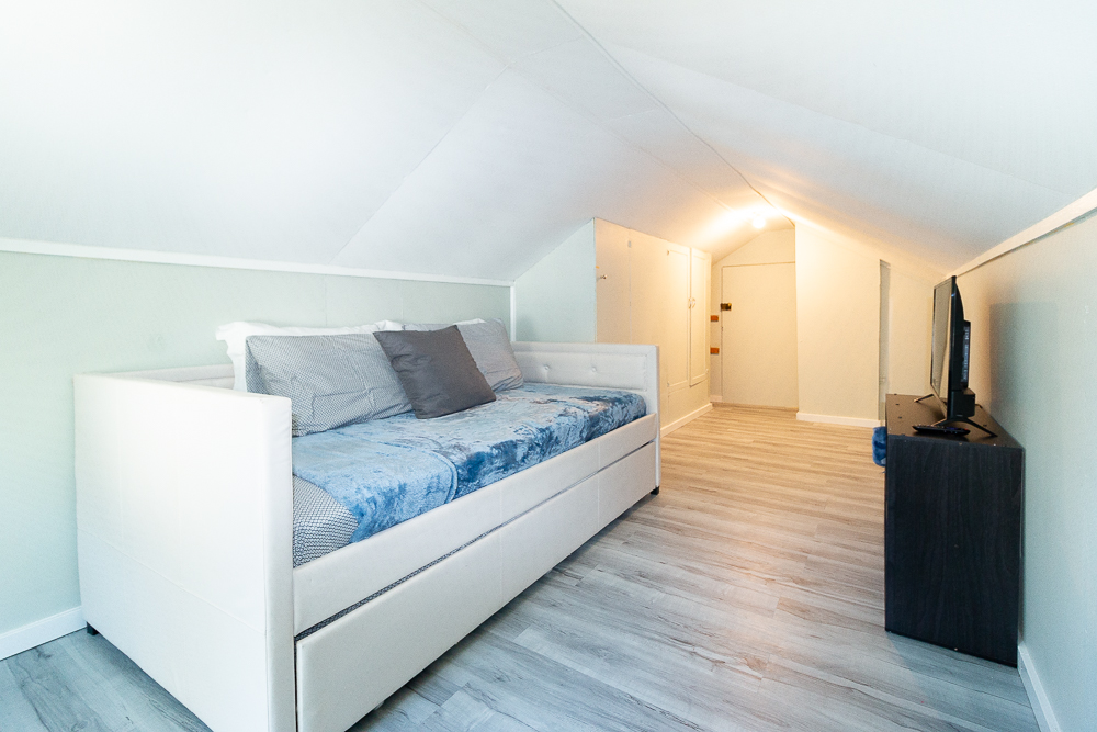 The loft offers a quiet, inviting space to unwind with a comfy daybed and TV.