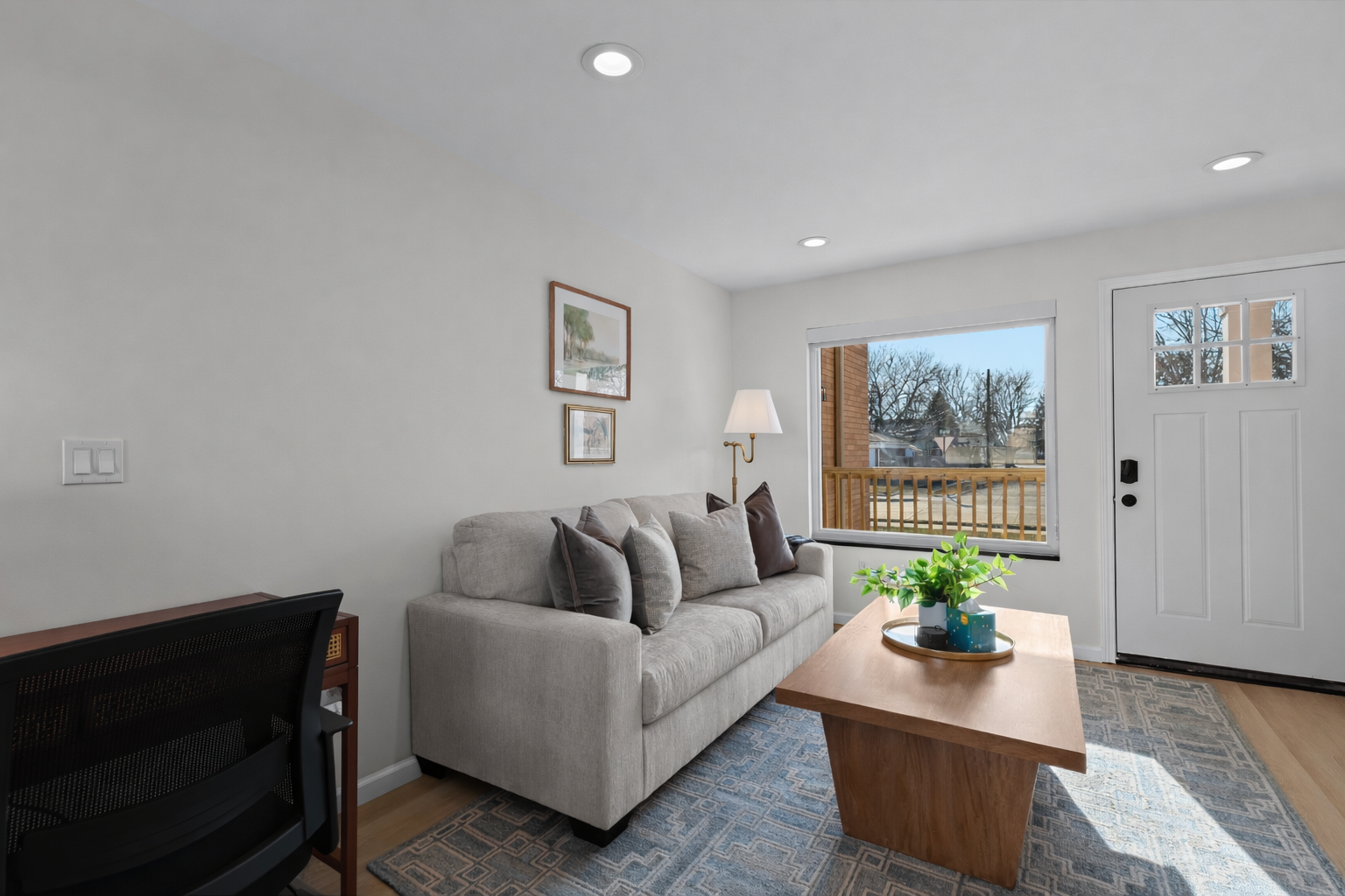 Bright, modern living room with plush seating, clean lines, and a large window that fills the space with natural light and a warm, welcoming feel.