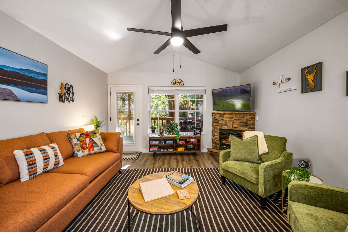 This inviting living room features cozy seating, a stone fireplace, and a smart TV—perfect for relaxing after a day of exploring. Board games and warm touches make it feel just like home!