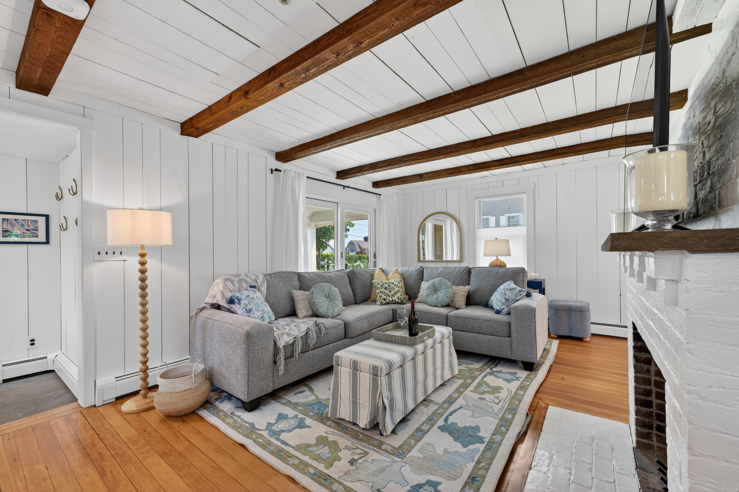 Bright and welcoming living area featuring expansive windows, soft natural lighting, and a comfy setup ideal for unwinding or socializing.