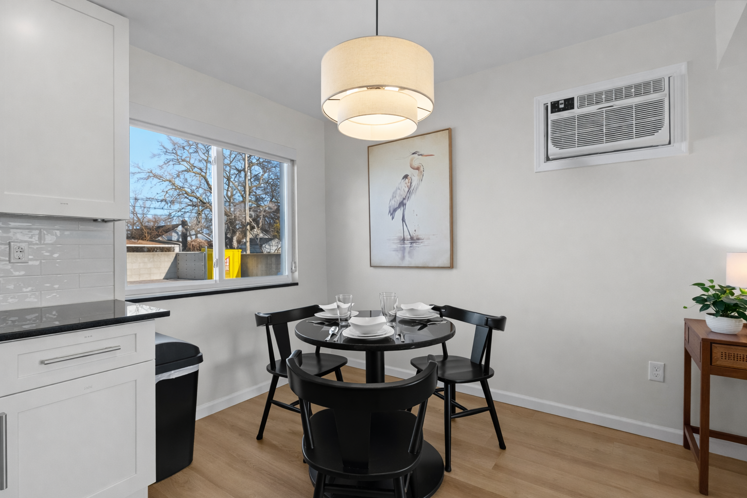 Modern dining area with stylish lighting, seating for four, and natural light—perfect for relaxed meals, morning coffee, or casual evenings together.