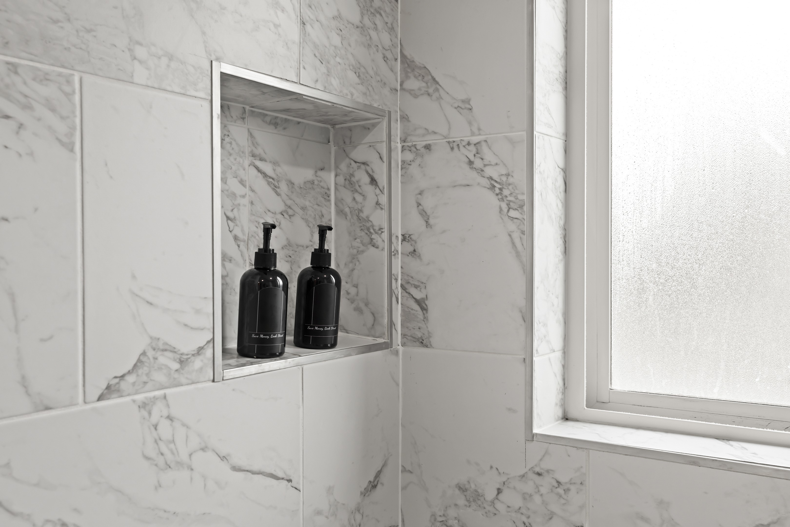 Modern bathroom with full-size tub, granite vanity, and bright lighting.