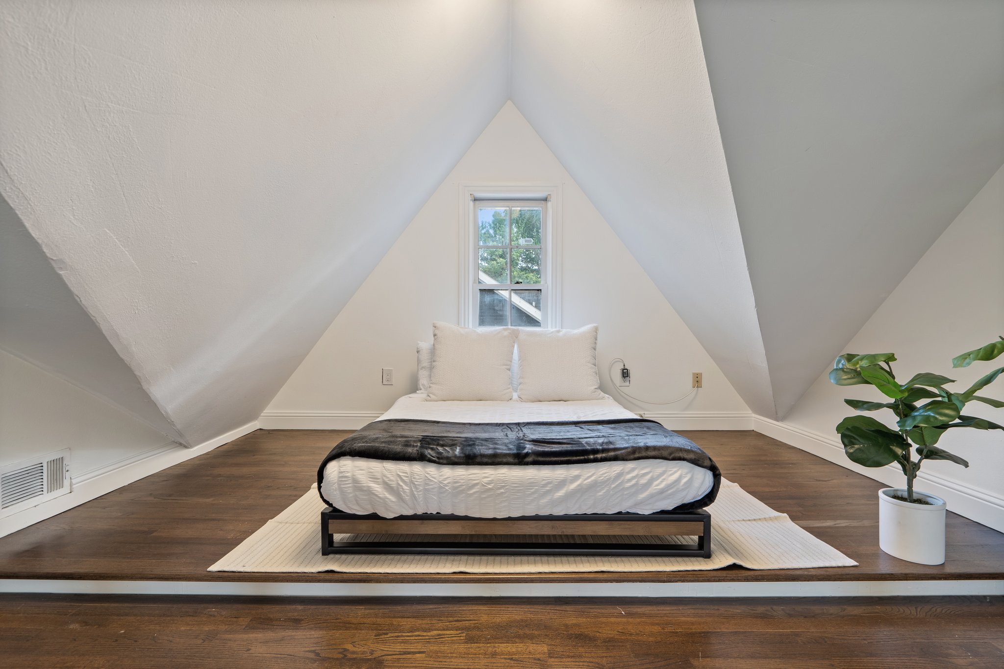 Open loft Double Bed with vaulted ceiling, natural light, and hotel-style linens. Extra pillows and blankets provided. Upper level of main house, open layout with room-darkening shades and clothing storage.