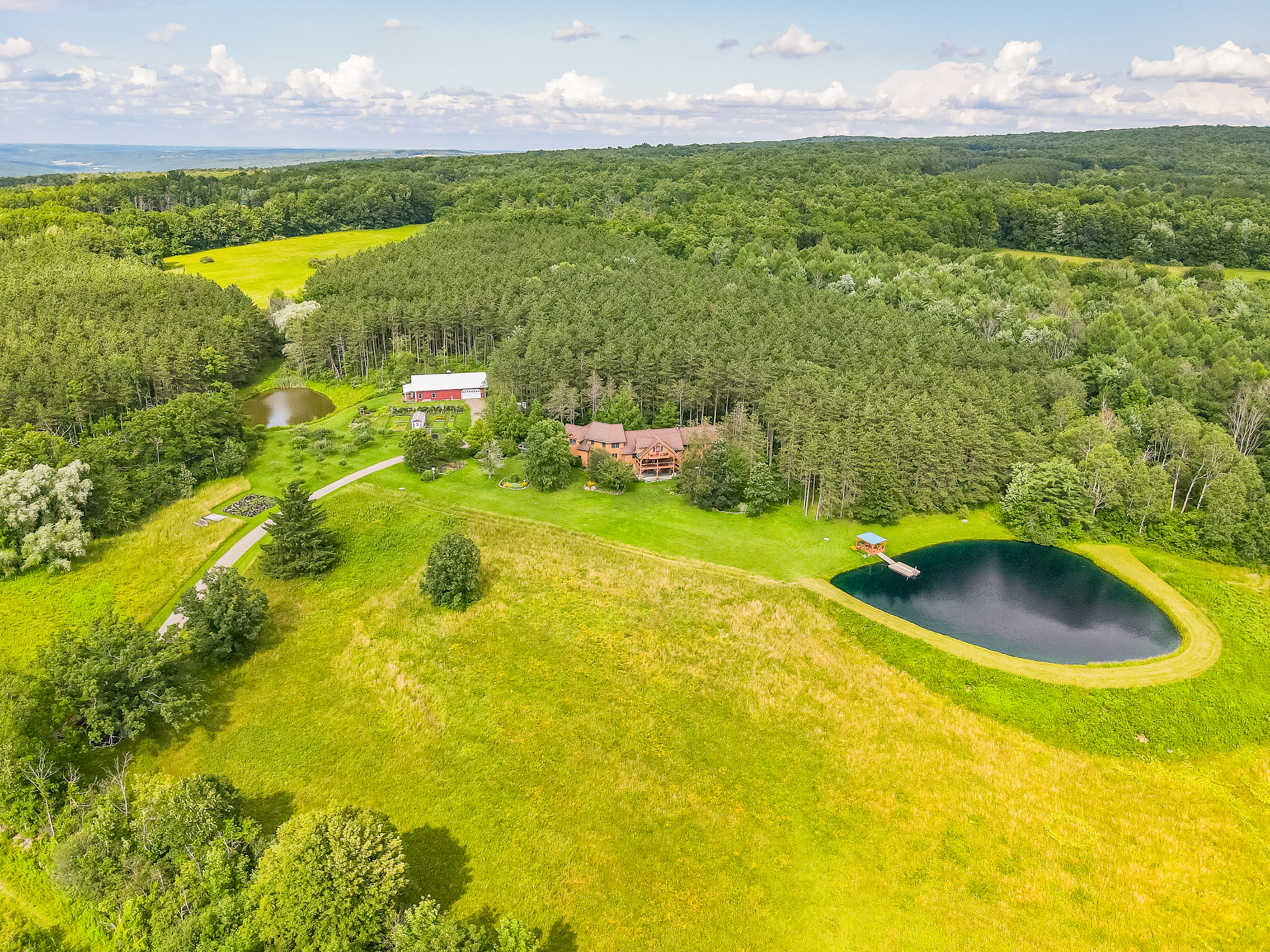 Escape to your own private retreat surrounded by rolling hills and forest. This stunning property features a spring-fed pond with a dock, wide-open meadows, and total privacy—perfect for relax