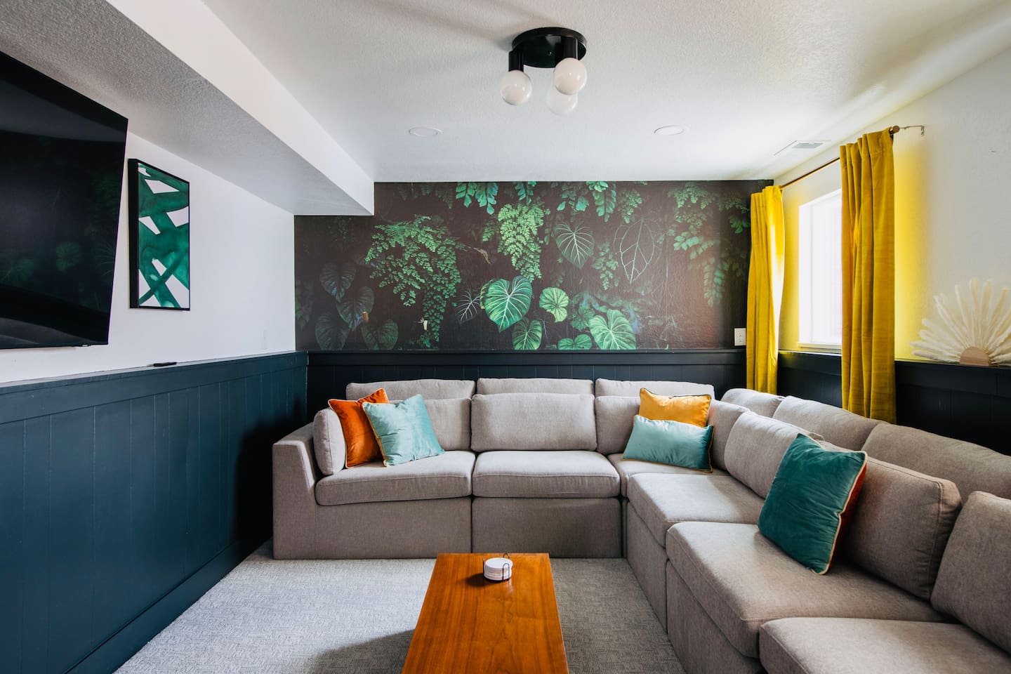 Stylish lounge with large sectional sofa and smart TV perfect for movie nights.