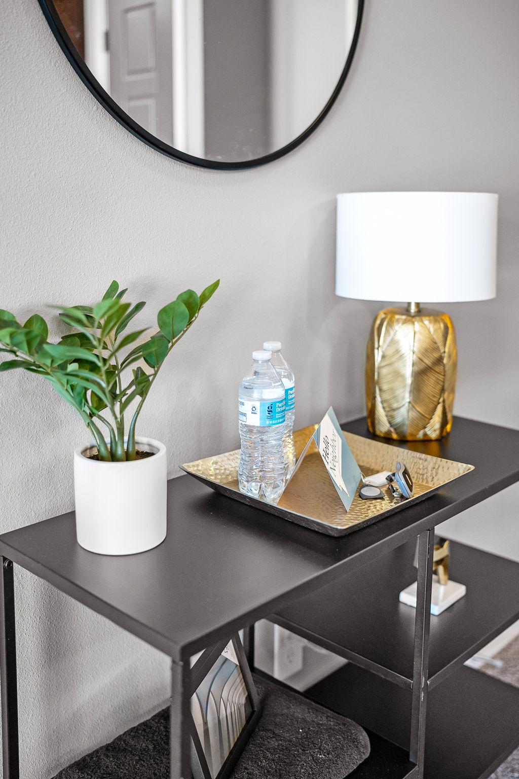 A warm welcome awaits! Enjoy complimentary bottled water, a sleek gold tray for keys and accessories, a modern lamp, and greenery that adds a fresh touch to your arrival.