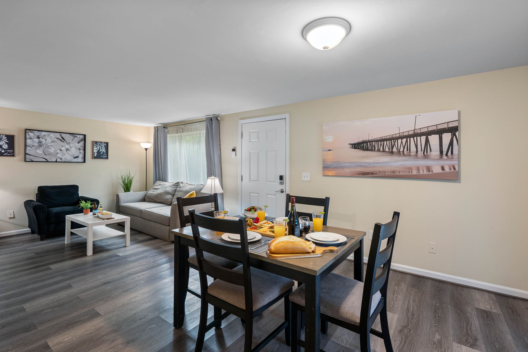 Featuring a solid wood dining table with a natural finish and four cushioned chairs in a sleek dark frame.
