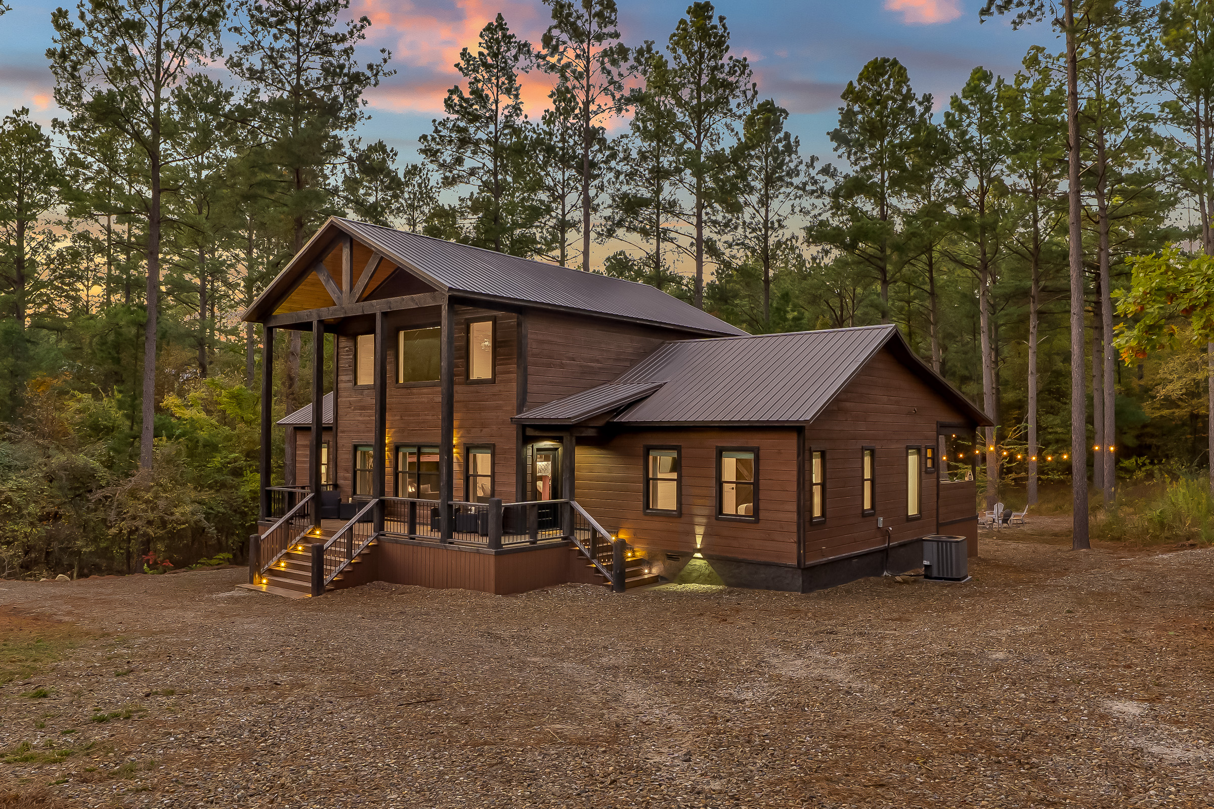 Golden hour glow on the cabin exterior, showcasing its modern rustic design and peaceful wooded backdrop.