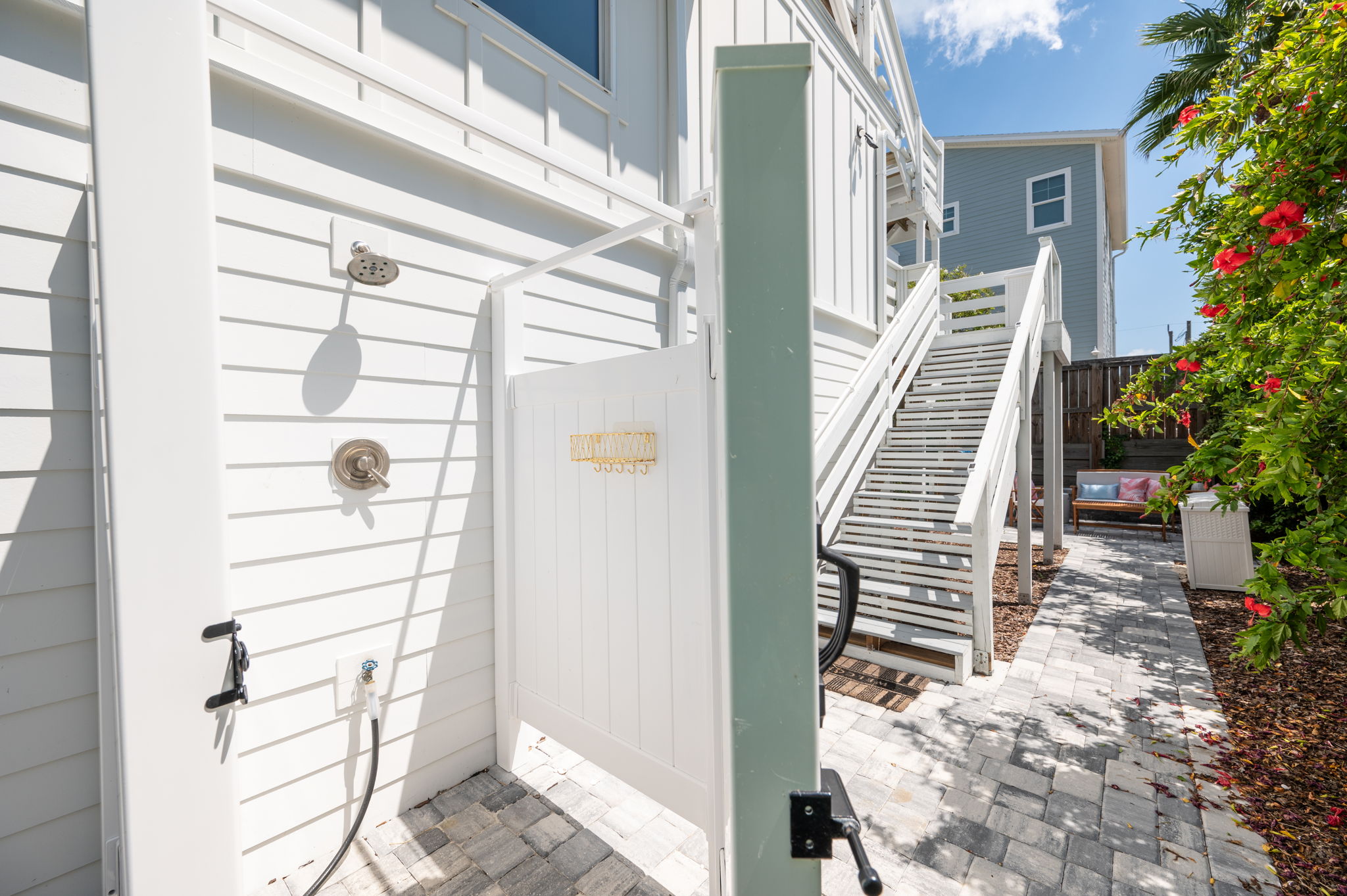 Here’s the outdoor shower, perfect for rinsing off after a day at the beach. Beneath the stairs, leading from the deck to the patio, you’ll find a collection of beach gear—chairs and a wagon—for our guests to use during their stay!