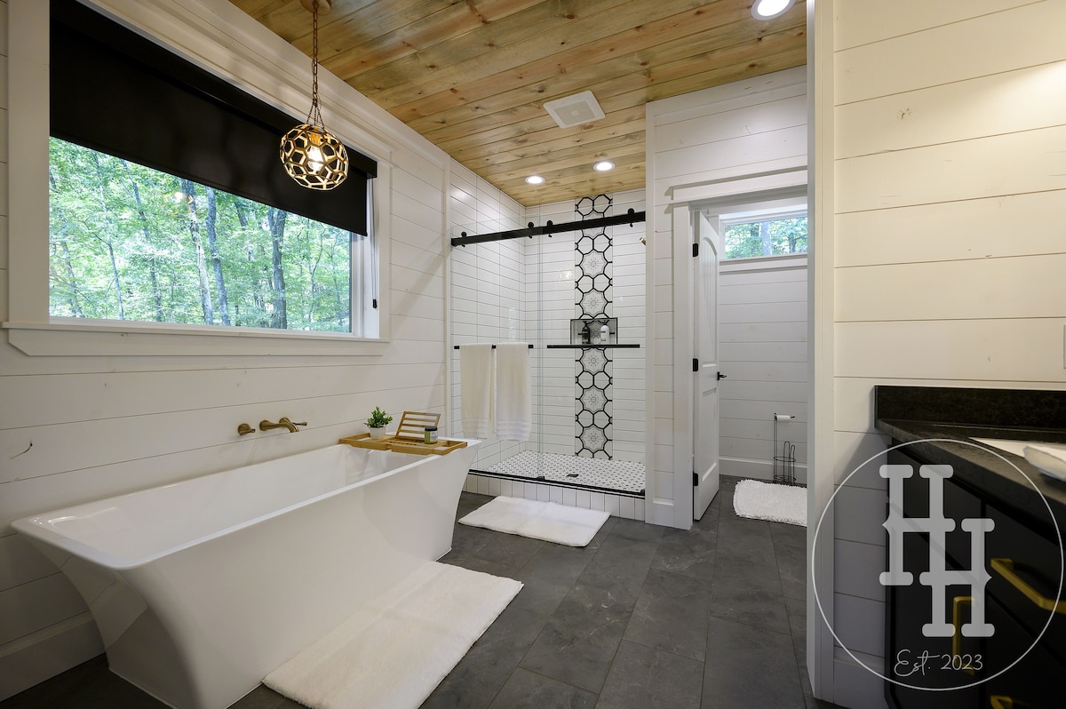 Spacious master bathroom with natural light and privacy shades