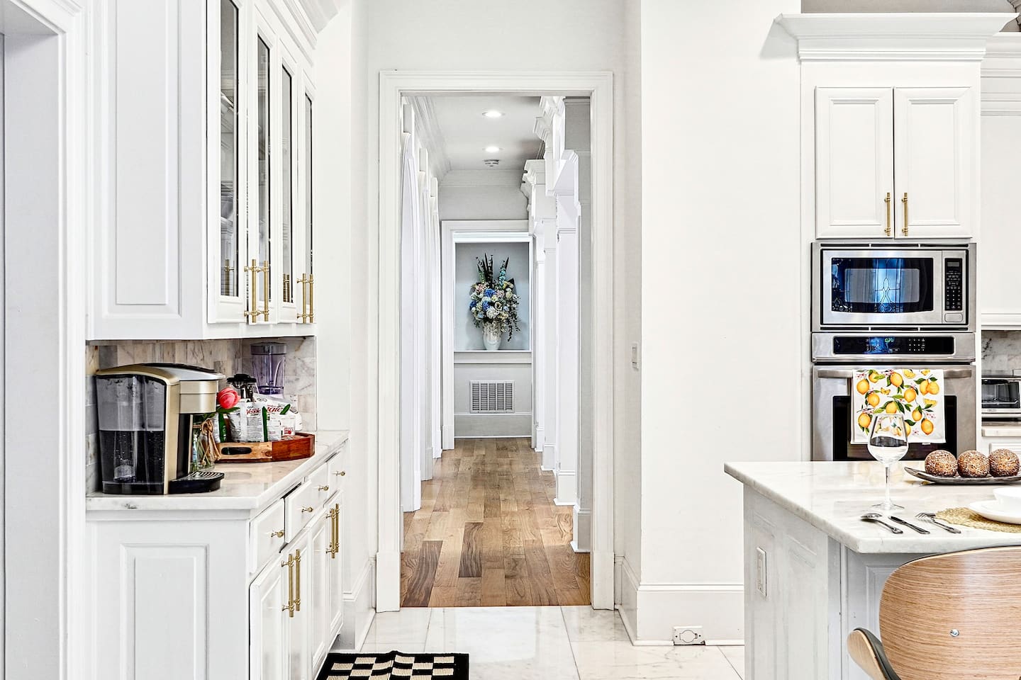Bright and beautifully designed kitchen with white marble counters and white wood cabinetry. Fully equipped and ideal for cooking, gathering, and hosting with ease.