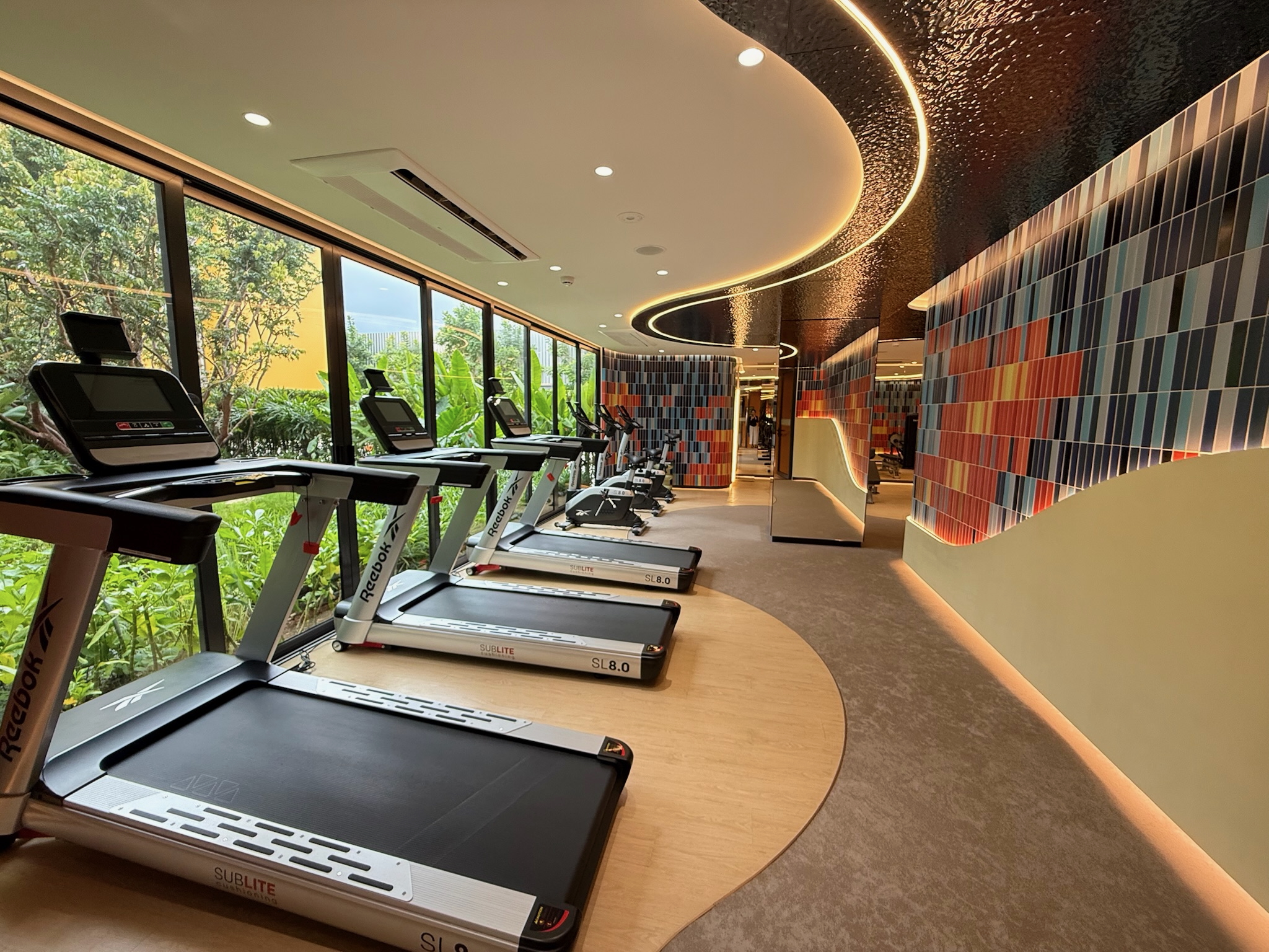 Enhance your workout—whether strength training or cardio—with an underwater-themed space featuring coral murals and garden views.