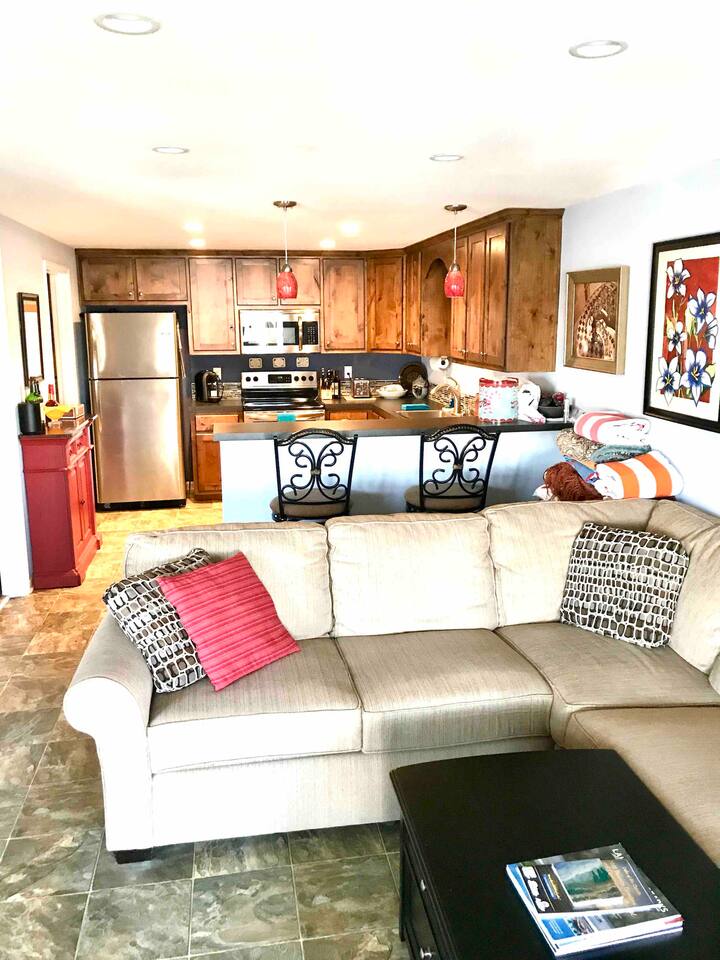 Open concept kitchen and living room with swivel bar height chairs for dining at the kitchen bar and swivel to look at the lake views. 
