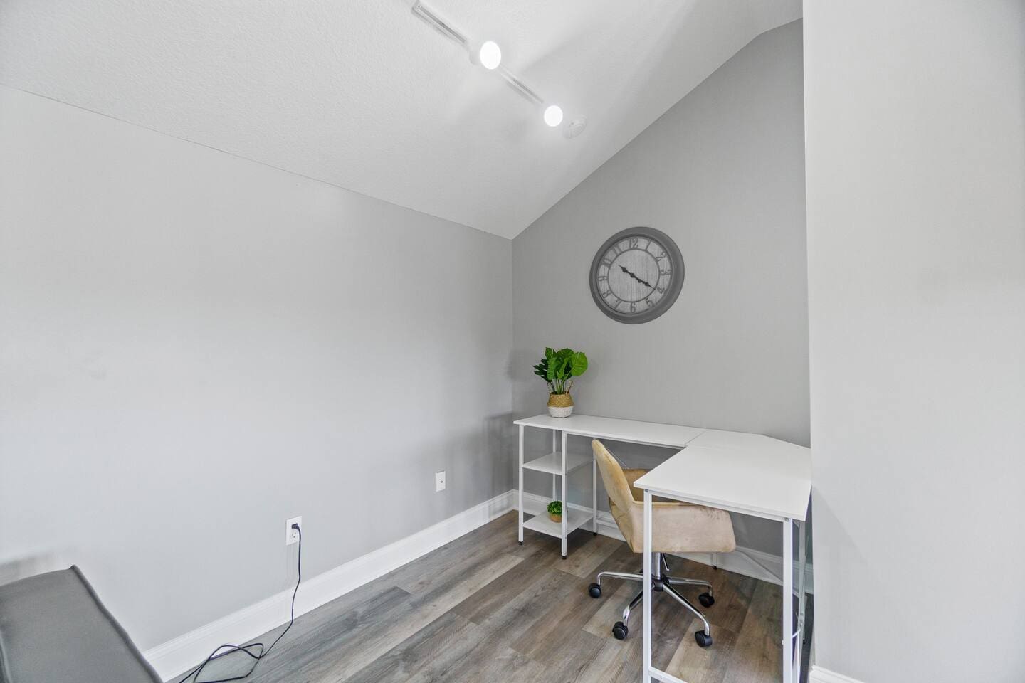 Dedicated workspace with a functional desk, comfortable chair, and ample lighting, perfect for productivity and focus.