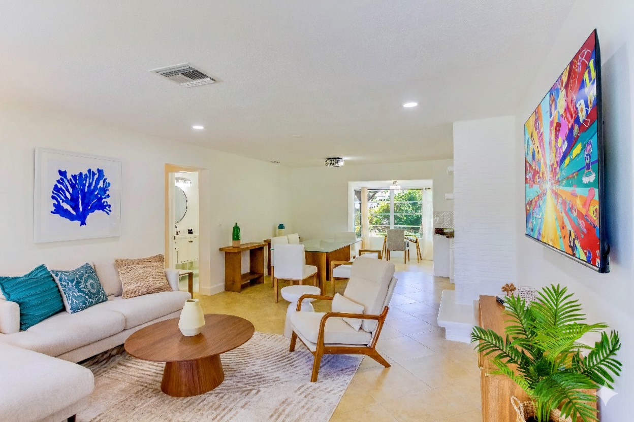 Beautifully designed living space with comfortable seating, coastal artwork, and a large Roku TV for entertainment.