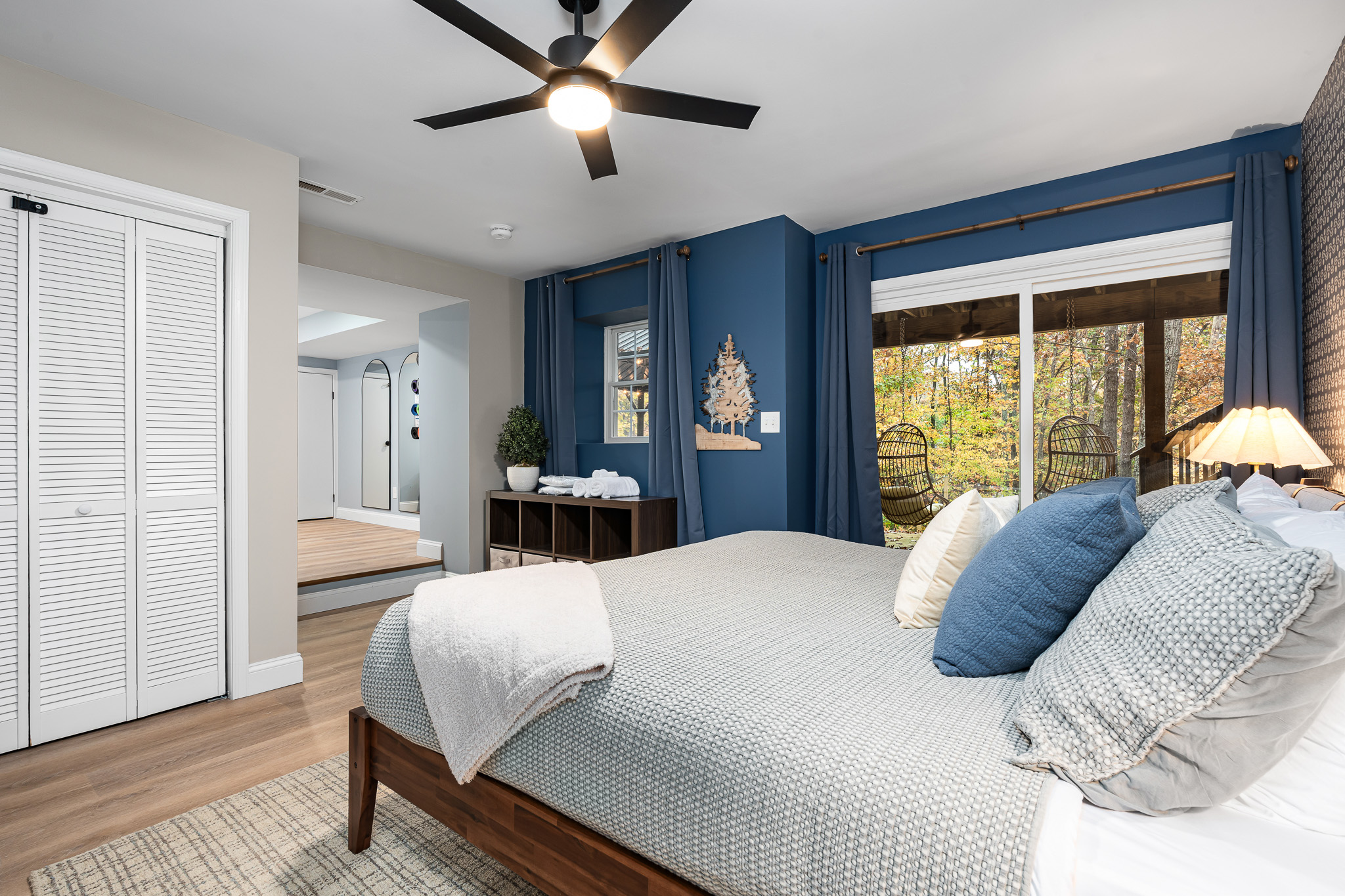 Wake up to forest views in this spacious bedroom with walkout deck access. A peaceful retreat for early risers who love morning coffee outdoors or anyone craving quiet moments away from the main gathering spaces.