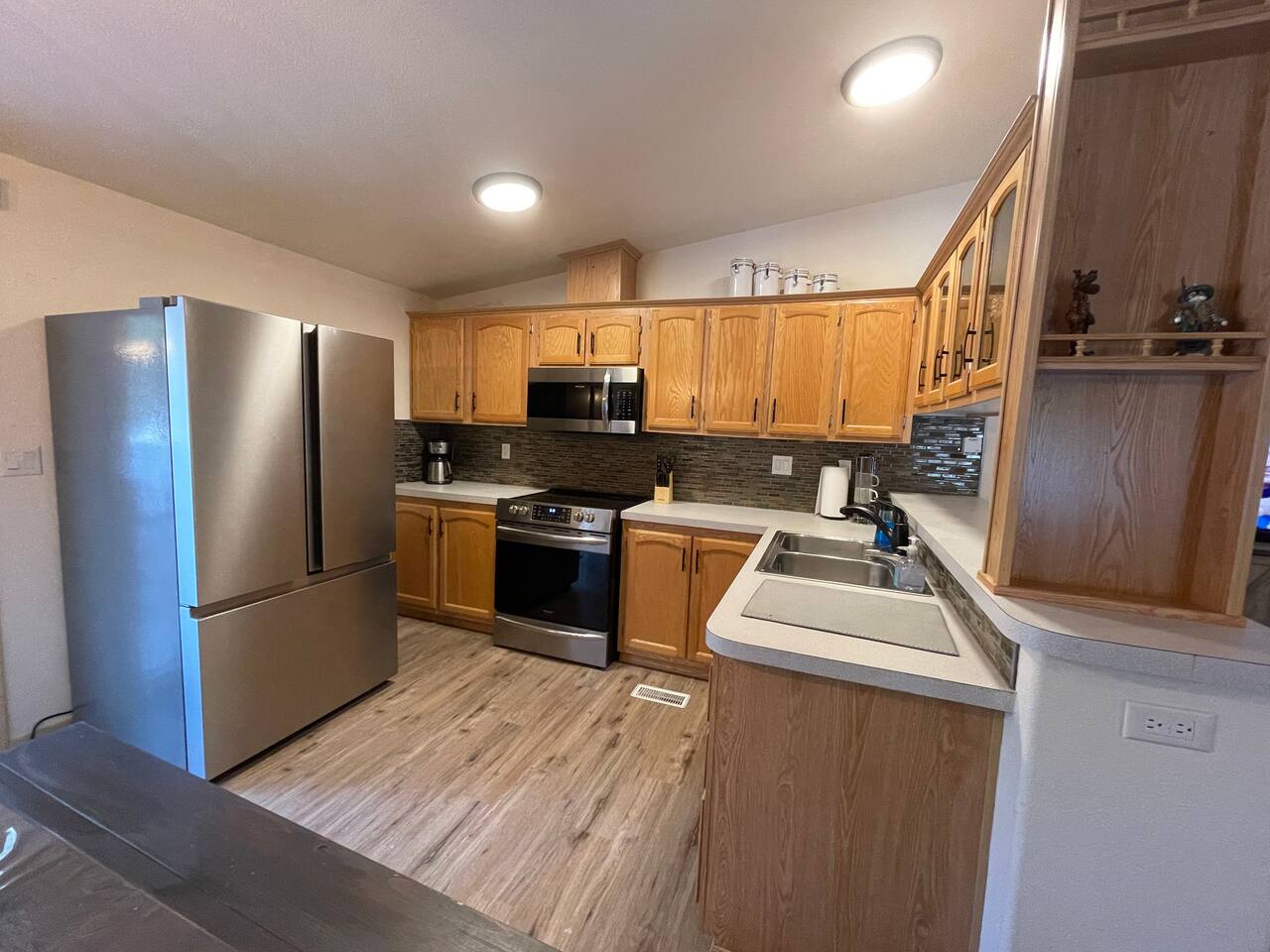 Kitchen with Updated Appliances, Backsplash, Faucet, Cupboard Door Handles, Light, Table, and Flooring