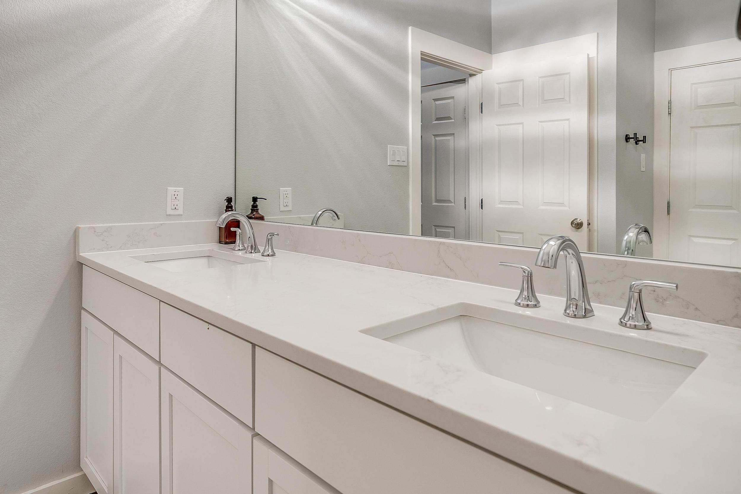 Double vanity bathroom with sleek modern finishes—stocked and spotless.