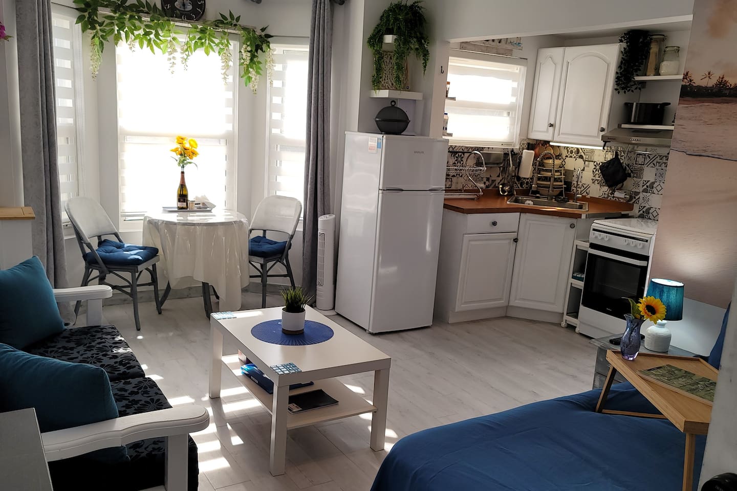 Living area with sofa that converts to 2 single beds, dining area and full kitchen