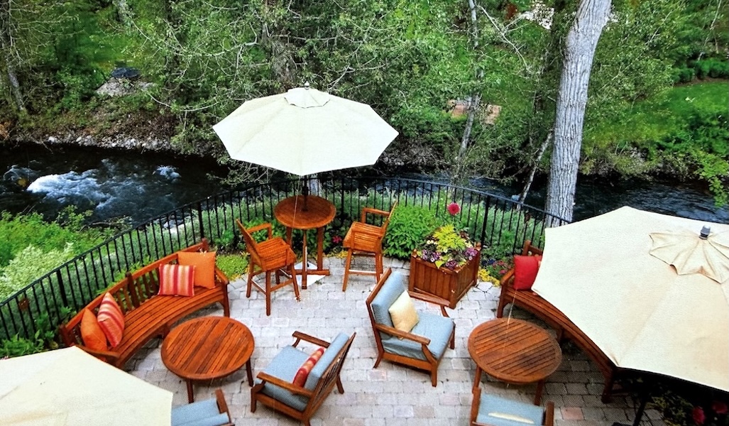 Furnished patio overlooking Trail Creek with sitting area, dining table, and grill