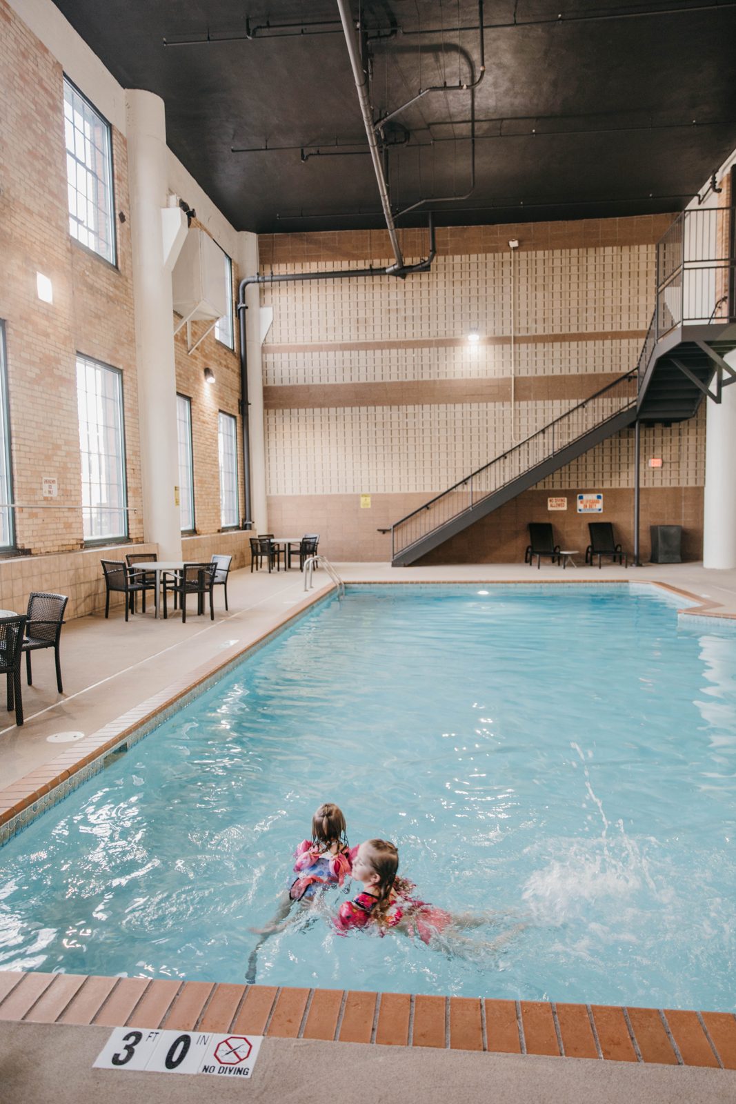 Two kids swimming in the indoor pool at the Waterfront Plaza building in Canal Park