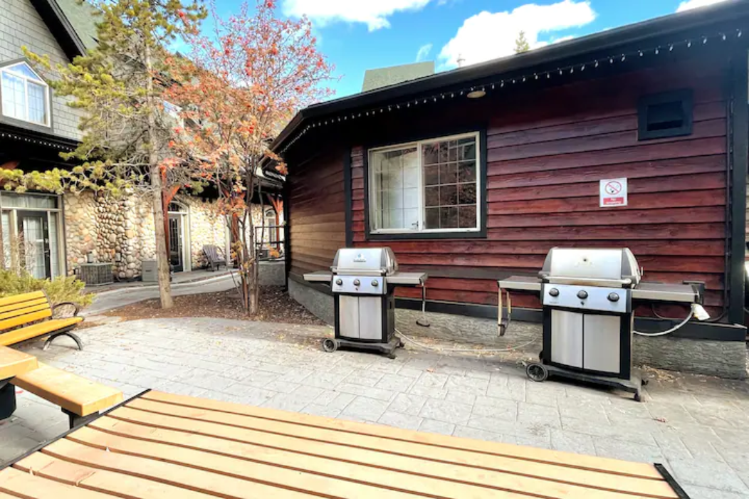 Shared BBQ area with picnic tables located in beautiful open space main courtyard.