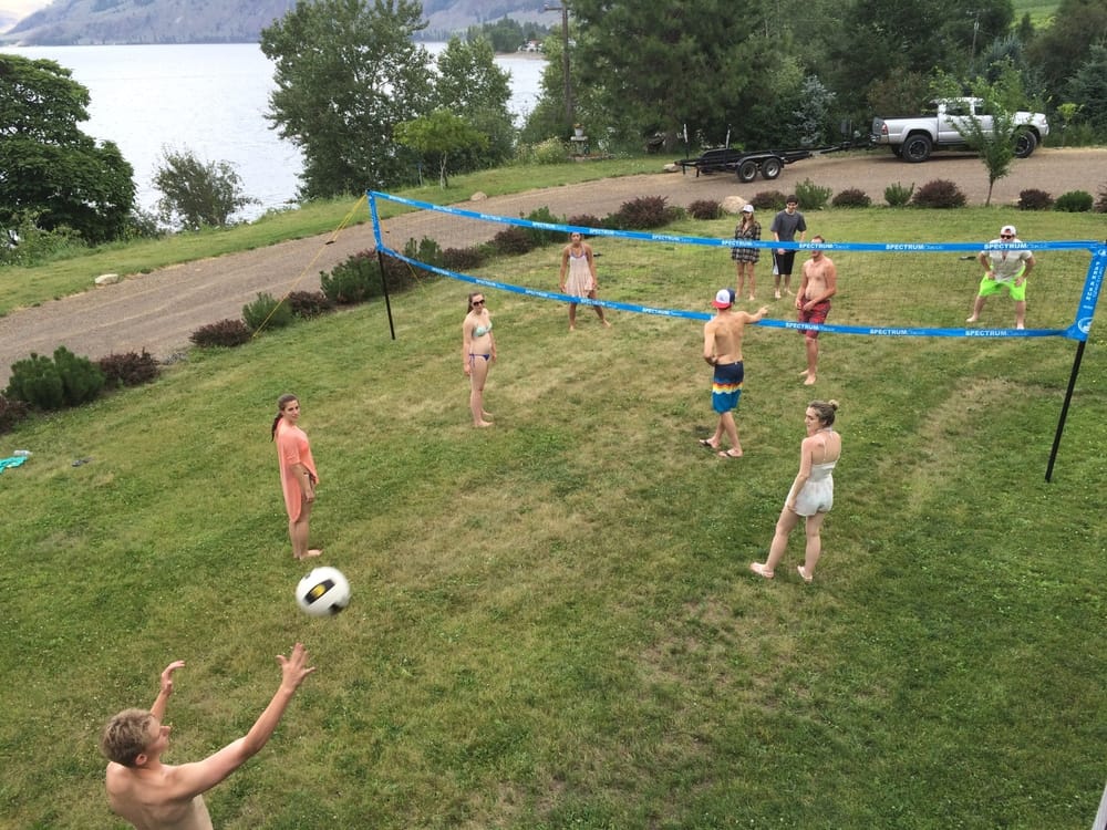 Kids and adults playing volleyball on the lodge lawn