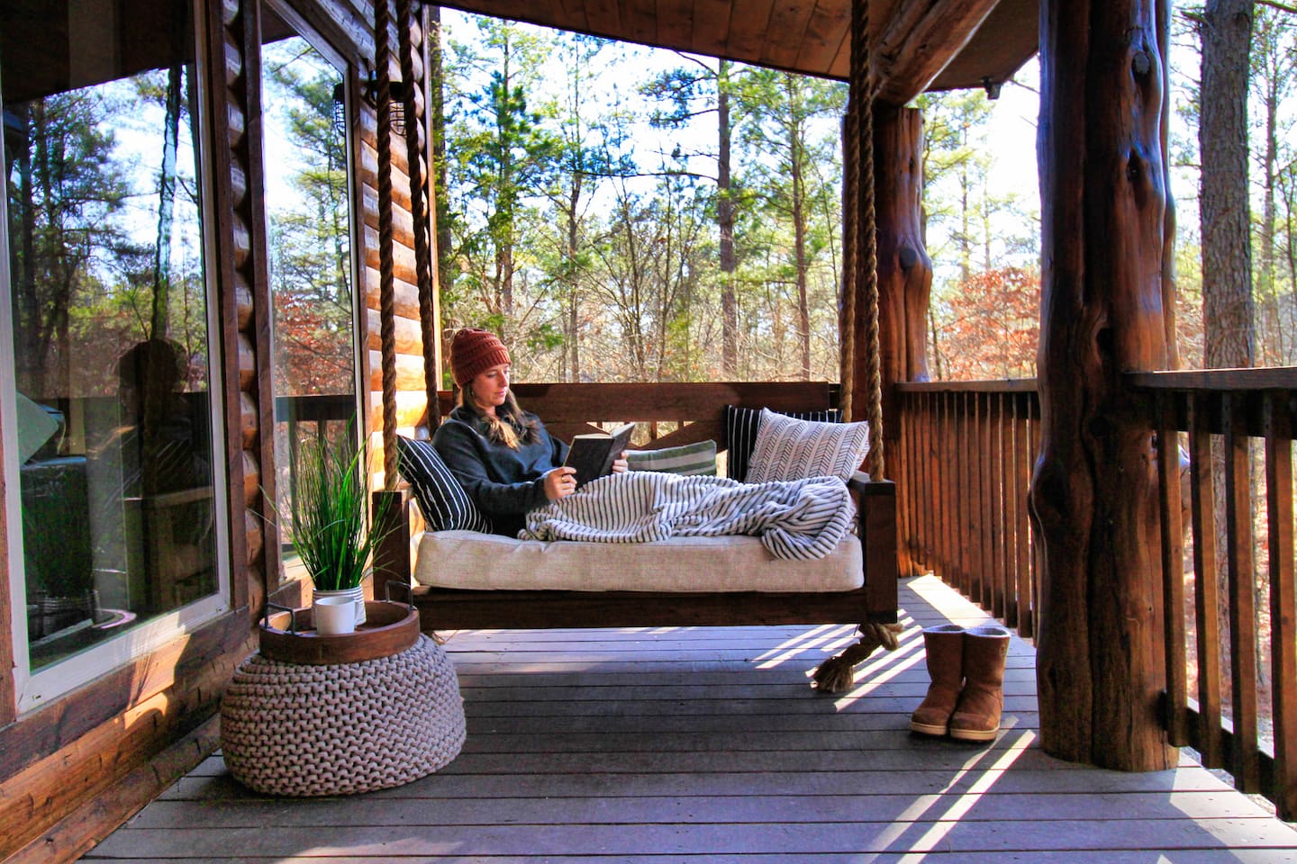 Relax under the covered porch on the cozy swing bed, perfect for quiet afternoons, reading, or soaking in peaceful forest views