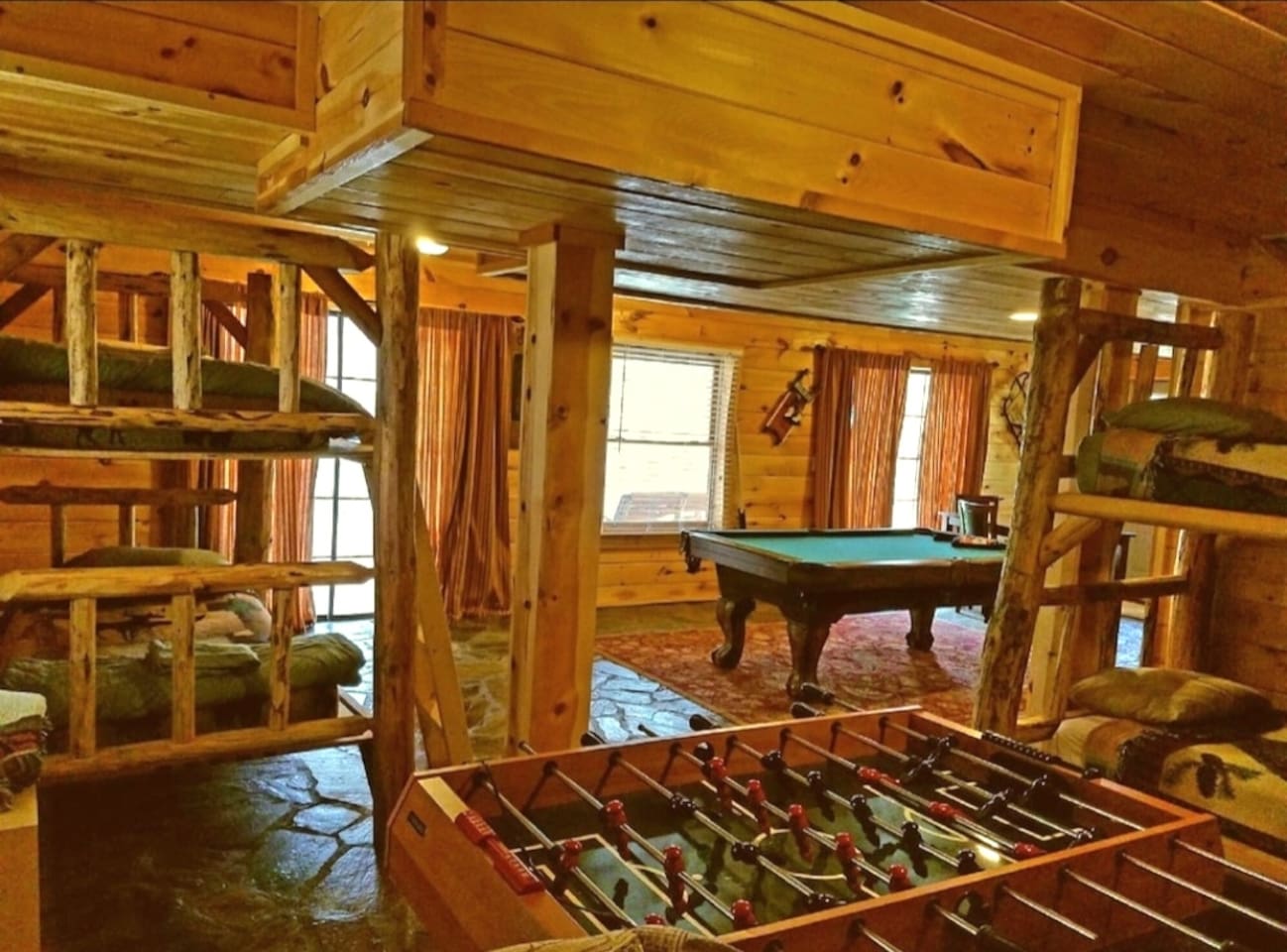 Large lower level game room with pool table and foos ball table, games two sets of log bunk beds, full bath, washer/ dryer and a table that seats four. Two sets of sliding glass doors open to the lower level deck , hot tub and back yard with stream.
