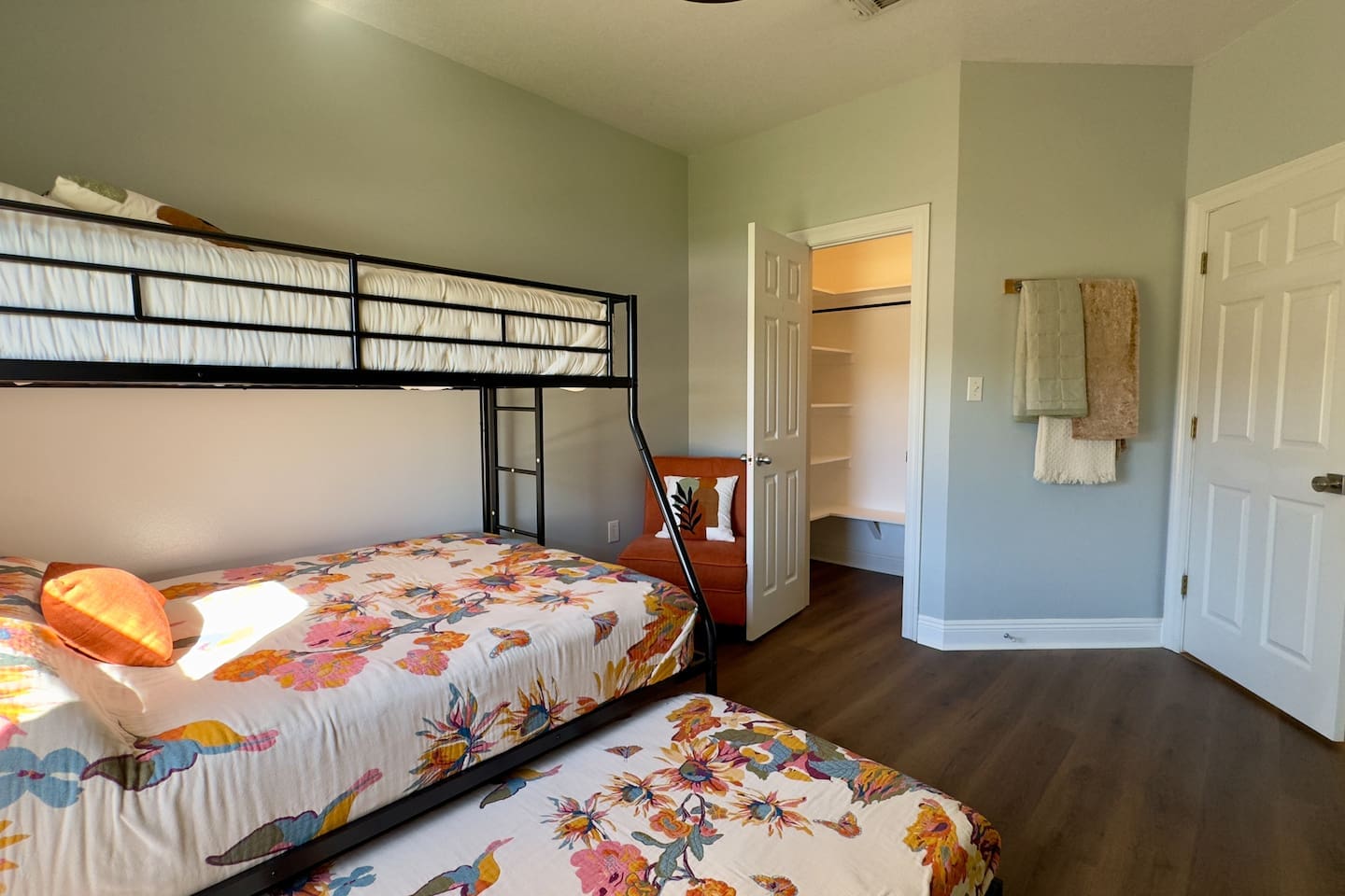 A  metal-framed bunk bed with twin-over-full mattresses plus a pull-out trundle offers space for multiple guests.
