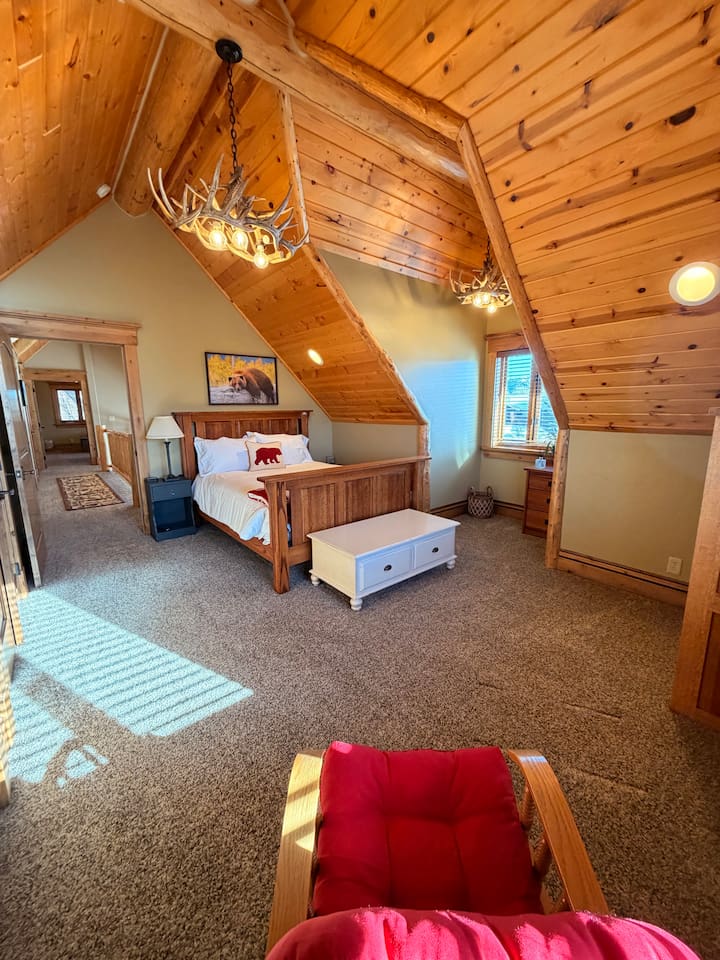 Bedroom 5 is a loft-style retreat, featuring vaulted wood ceilings and beautiful rustic details that create a true lodge experience. Filled with natural light, this upper-level sanctuary offers a queen bed with premium linens -perfect for recharging.