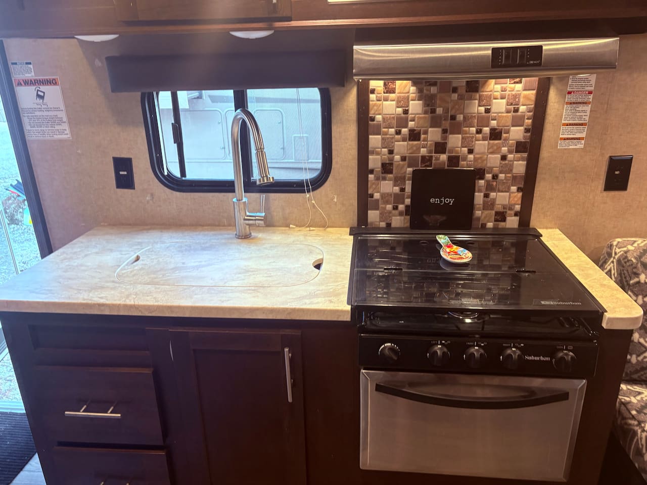 Kitchen area - 3 burner stove, oven, and sink.
