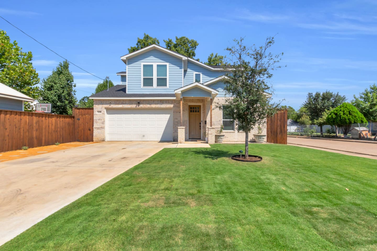 Contemporary exterior with blue siding and clean driveway.
